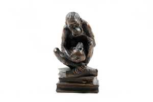 Bronzed figure of a monkey on books