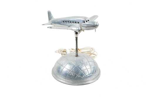Vintage aluminium figural table lamp of a DC3 flying over the world