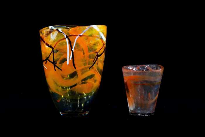 Two Kosta Boda glass vessels with orange swirl design