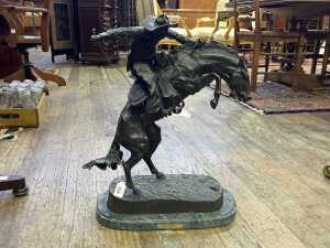 After Frederic Remington, Bronco Buster, cast bronze figure.