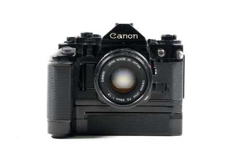 Canon A-1 SLR film camera with three lenses and accessories