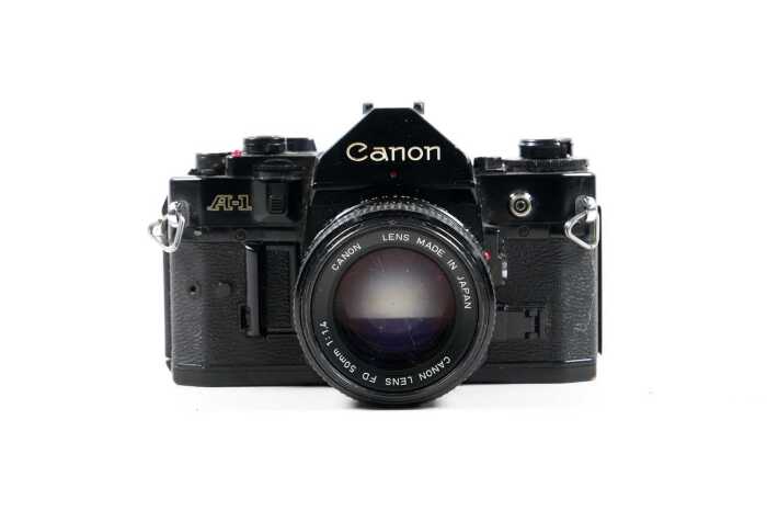 Canon A-1 SLR film camera with two lenses and accessories