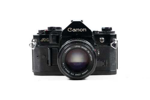 Canon A-1 SLR film camera with two lenses and accessories
