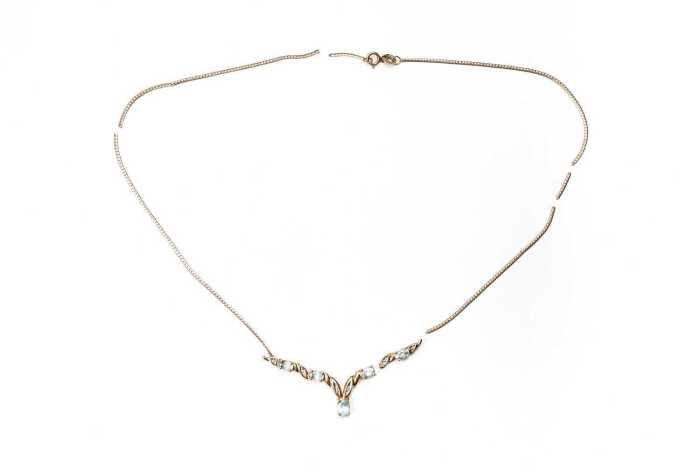 A broken blue topaz and diamond necklace in 9 carat yellow gold