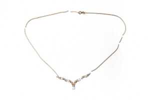 A broken blue topaz and diamond necklace in 9 carat yellow gold