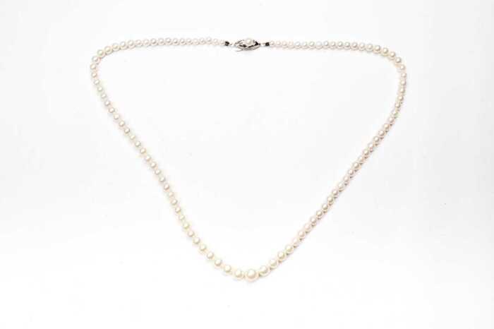 A strand of graduated pearls to a silver clasp