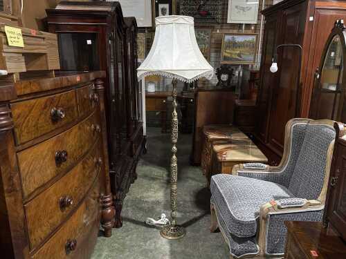 Vintage brass floor lamp with intricate cut-outs with fabric fringed shade.