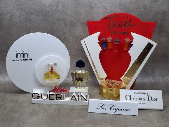 Five perfume shop displays and placards, some with perfume bottles