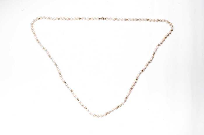 A semi baroque pearl necklace to a 14 carat yellow gold clasp