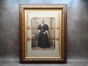Antique photographic studio portrait of a standing woman