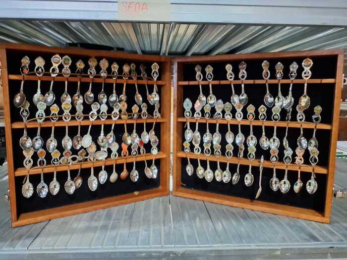 Collection of souvenir spoons in timber canteen
