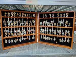 Collection of souvenir spoons in timber canteen