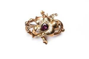 An antique floral garnet and enamel brooch in 15 carat yellow gold