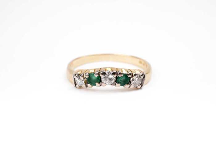 An emerald and diamond ring in 18 carat yellow gold