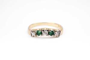 An emerald and diamond ring in 18 carat yellow gold