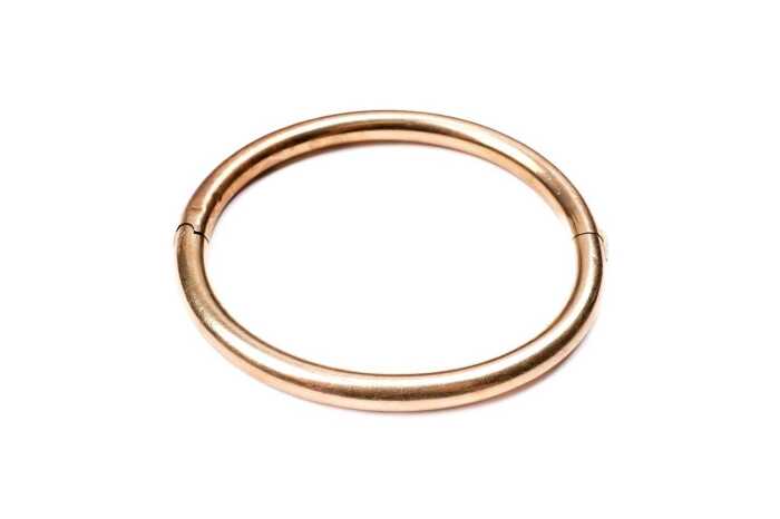 An antique hinged bangle in 15 carat yellow gold