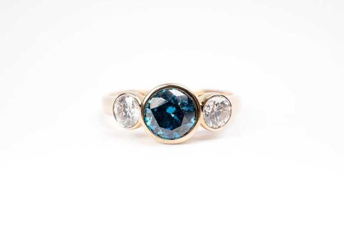A treated blue and white diamond ring in 14 carat yellow gold