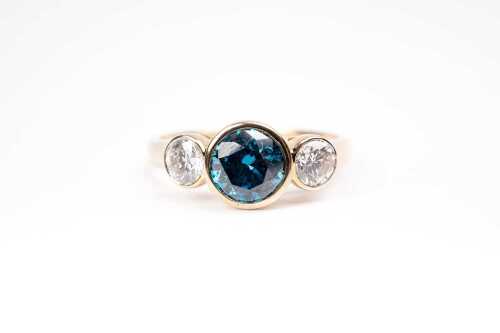 A treated blue and white diamond ring in 14 carat yellow gold