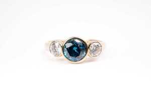 A treated blue and white diamond ring in 14 carat yellow gold