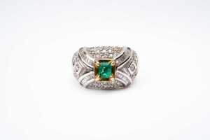 An emerald and diamond ring in 18 carat yellow gold