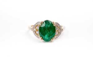An emerald and diamond ring in 14 carat yellow gold