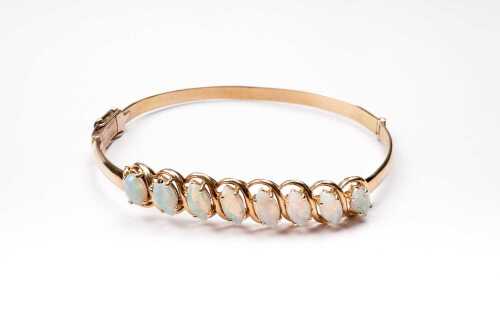 A vintage opal bangle in 14 carat yellow gold