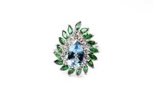 A aquamarine, tsavorite garnet and diamond ring in 14 carat white gold