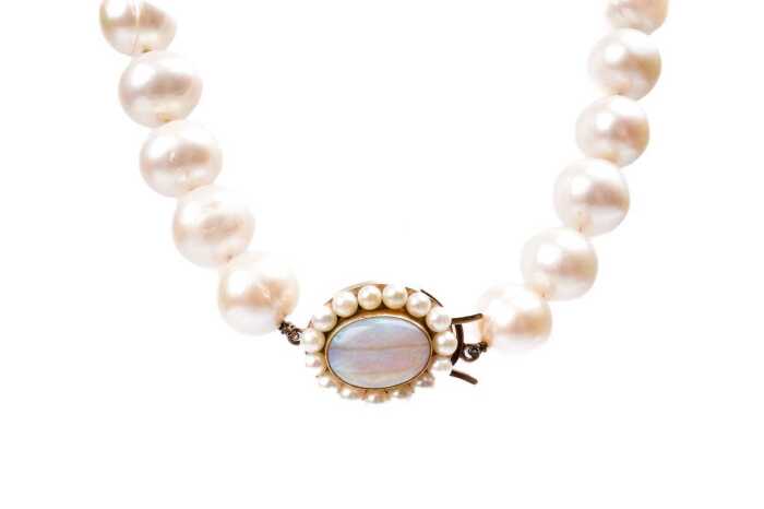 An Opera length strand of pearls to a opal and pearl clasp in 9 carat yellow gold