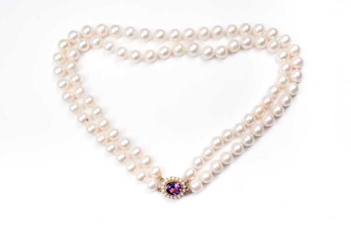 A double strand of pearls to a amethyst and pearl clasp in 9 carat yellow gold