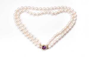 A double strand of pearls to a amethyst and pearl clasp in 9 carat yellow gold