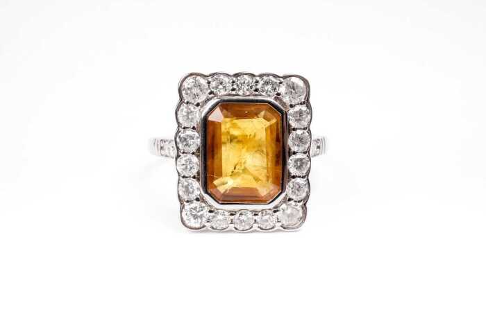 A yellow sapphire and diamond ring in 14 carat white gold
