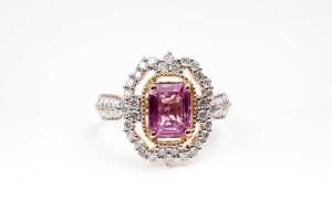 A pink sapphire and diamond ring in 14 carat yellow gold