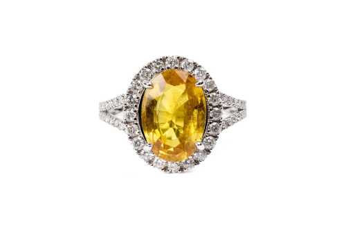 A yellow sapphire and diamond ring in 14 carat white gold