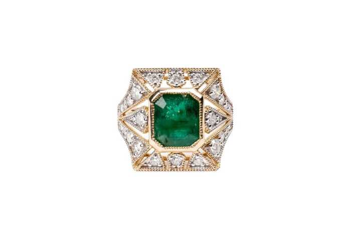 An emerald and diamond ring in 14 carat yellow gold