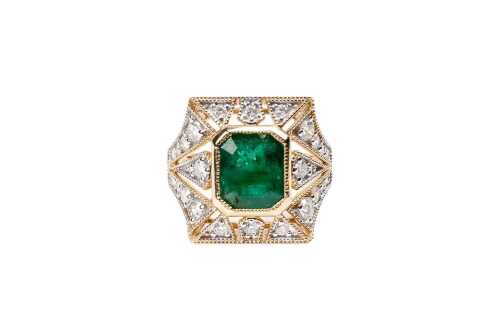 An emerald and diamond ring in 14 carat yellow gold