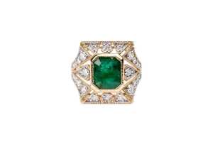 An emerald and diamond ring in 14 carat yellow gold