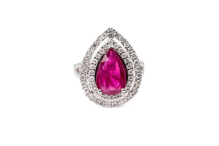 A ruby and diamond halo ring in 14 carat white gold