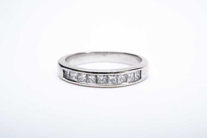A princess cut diamond band in 18 carat white gold