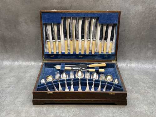 Assorted vintage cutlery in timber canteen