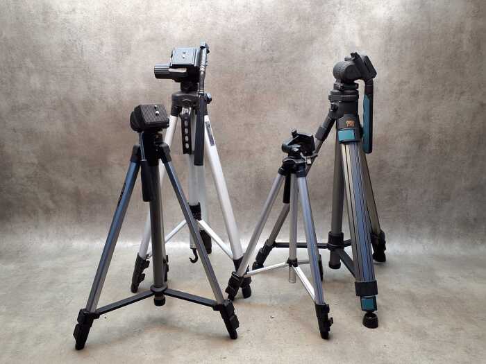 Four camera tripods with extendable legs, including Studio Systems