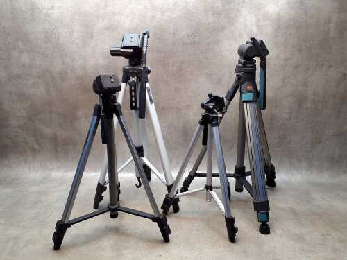 Four camera tripods with extendable legs, including Studio Systems