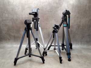 Four camera tripods with extendable legs, including Studio Systems