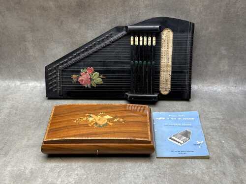Two vintage musical items including an autoharp with instruction booklet and a timber music box