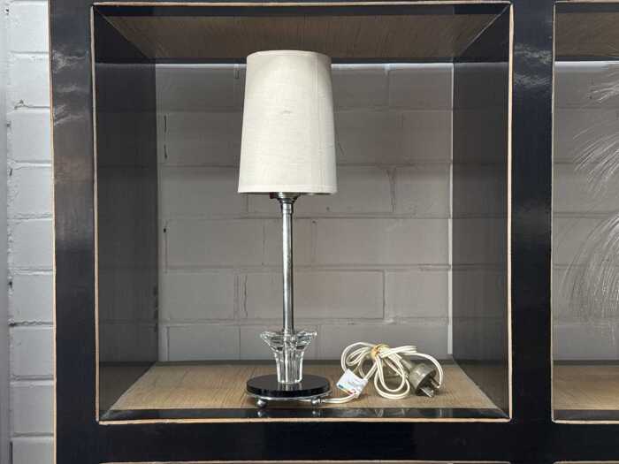 Art Deco table lamp with black and clear glass base and chrome stem.