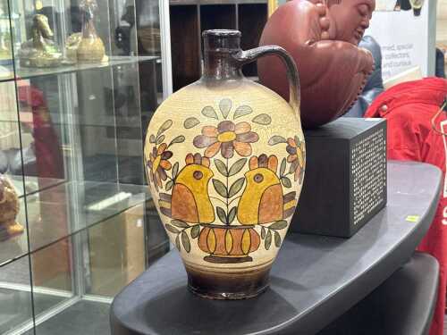 Folk art pottery jugs with hand-painted bird and floral design