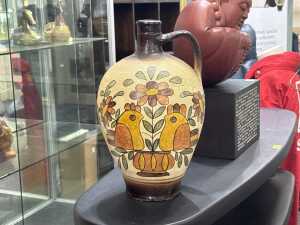 Folk art pottery jugs with hand-painted bird and floral design