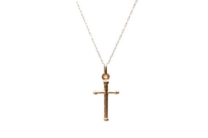 A cross pendant on a trace link chain in 9 carat yellow gold