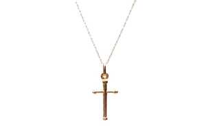 A cross pendant on a trace link chain in 9 carat yellow gold