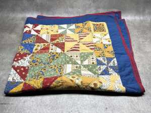 Patchwork blanket with hand-stitching in blue, red and yellow