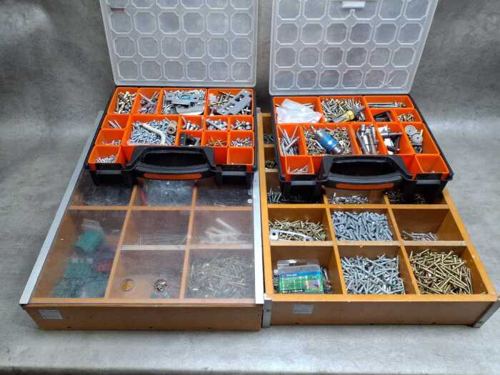 Four tool organisers filled with assorted screws, wall plugs, and bolts